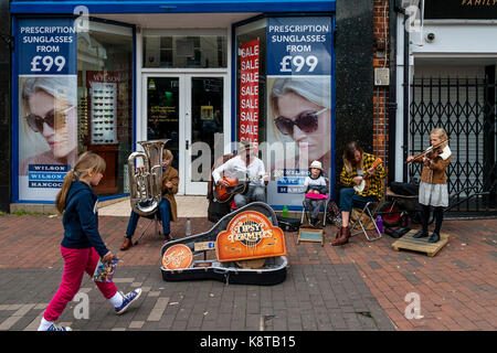 Une jeune famille d'amuseurs publics effectuer dans la high street, Lewes, East Sussex, UK. Banque D'Images