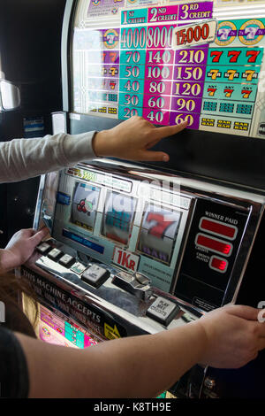 Les gens méconnaissables ou personne jouant sur coin slot machine modèle libération : pas de biens : non Banque D'Images