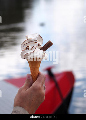 Whippy doux la crème glacée au chocolat avec des flocons. River s'est évanoui en arrière-plan. Banque D'Images