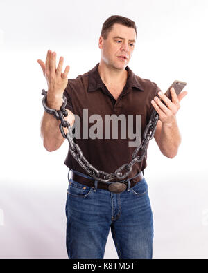 Homme adultes en détresse, enchaîné à son téléphone cellulaire. homme montrant les expressions faciales d'agonie et de désespoir Banque D'Images