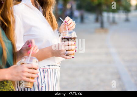 Deux jeunes filles ayant une tasse de café en plein air Banque D'Images