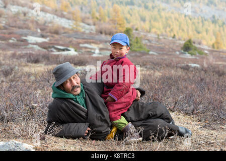 Garçon tsaatan et son grand-père vêtu d'un traditionnel deels reposant dans la nature Banque D'Images