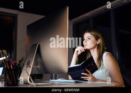 Businesswoman dans son bureau à la fin de travail de nuit. Banque D'Images