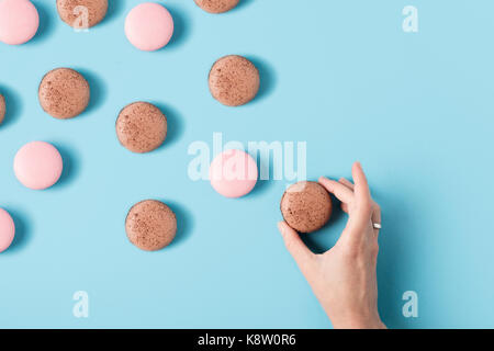 La main féminine et macarons Banque D'Images