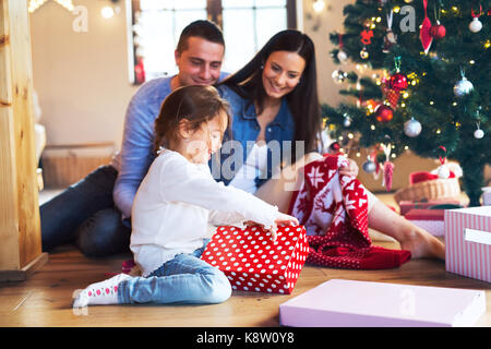 Jeune famille avec daugter à arbre de Noël à la maison. Banque D'Images