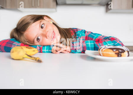 Kid choisir entre des légumes sains et savoureux bonbons Banque D'Images