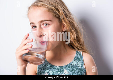 Happy smiling enfant de boire du lait au chocolat isolated on white Banque D'Images