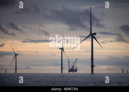 L'installation de l'ICM Seajacks Vestas Scylla aérogénérateurs) pendant le coucher du soleil sur le parc éolien de Walney Extension Banque D'Images