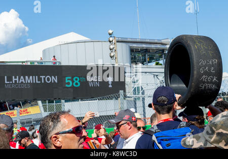 Homme portant un pneu slick course utilisé à la fin de la Grand Prix d'Italie 2017 à Monza avec Lewis Hamilton gagner 58 courses. Banque D'Images