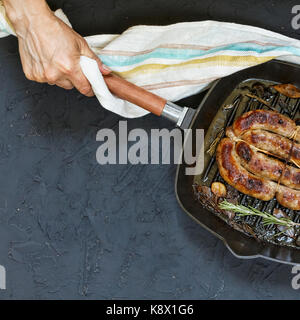 Des saucisses grillées servies par femme en mains barbecu Banque D'Images