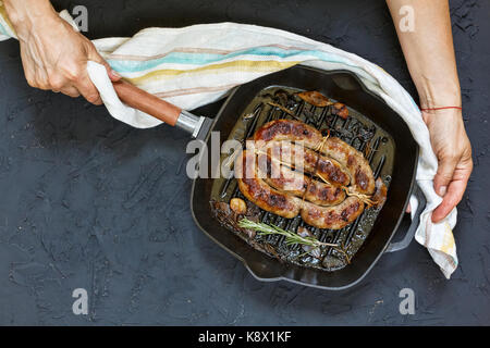 Des saucisses grillées servies par femme en mains barbecu Banque D'Images