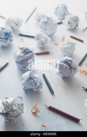 Close-up des boules de papier froissé sur un fond en bois blanc avec des crayons et des copeaux de crayon. écriture créative concept. high key toujours la vie. Banque D'Images