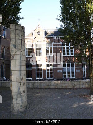 Ancienne école juive (1886) dans l'ancien quartier juif de Leeuwarden, Frise, Pays-Bas. Monument commémoratif en premier plan. Banque D'Images