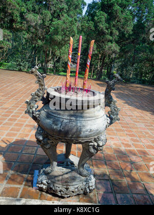 Close up de l'encens brûlant dans un temple bouddhiste à l'intérieur d'un énorme pot dans un patio d'un temple à Hué au Vietnam Banque D'Images