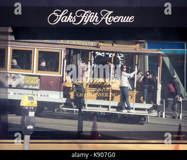 Une réflexion d'un hyde-powell street car depuis la fenêtre du magasin Saks Fifth Avenue at Union Square à San Francisco. Banque D'Images