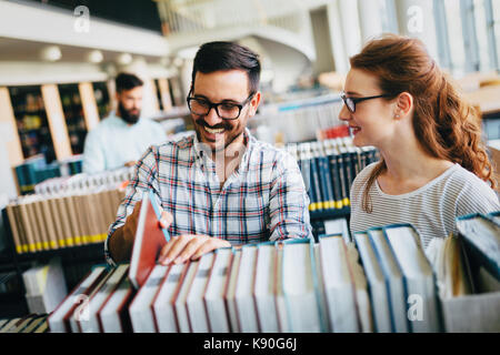 Les jeunes étudiants attrayant de son temps en bibliothèque Banque D'Images