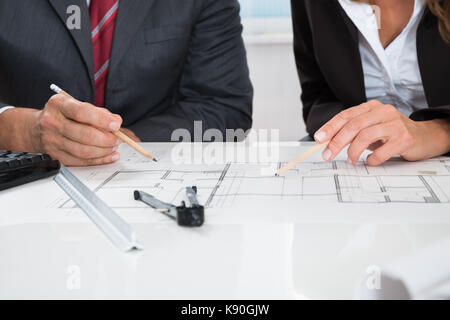 Close-up de deux mains d'architectes travaillant sur plan Banque D'Images