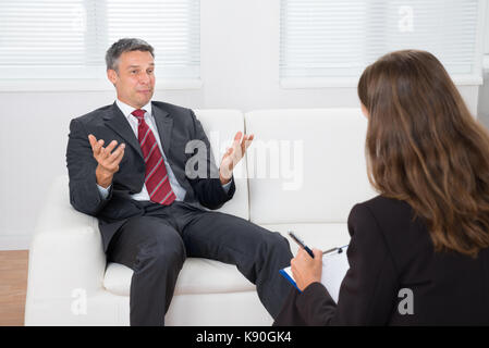 Homme patient sur la table de parler avec les professionnels psychiatre Banque D'Images