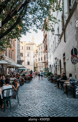 Restaurant trottoir avec les touristes dans une rue romaine d'été ensoleillé Banque D'Images