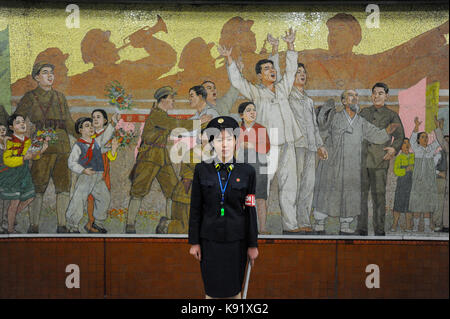 09.08.2012, Pyongyang, Corée du Nord, en Asie - une plate-forme Garde côtière canadienne se place en avant d'une vaste propagande murale intérieur d'une station de métro de Pyongyang. Banque D'Images