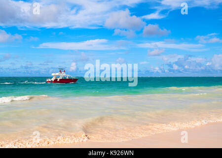 Paysage de la côte caraïbes. rouge bateau à moteur s'approche de l'océan atlantique, la Côte d'Hispaniola, la République dominicaine bavaro beach. Banque D'Images