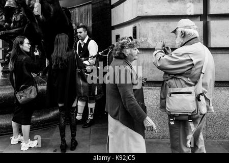 Les femmes qui discutent avec un artiste de rue, Piccadilly Circus, Londres, UK Banque D'Images