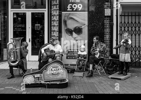 Une jeune famille d'amuseurs publics effectuer dans la high street, Lewes, East Sussex, UK. Banque D'Images