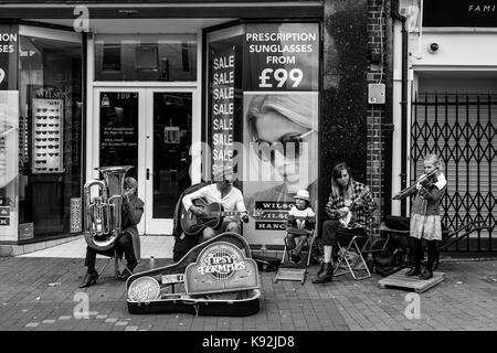 Une jeune famille d'amuseurs publics effectuer dans la high street, Lewes, East Sussex, UK. Banque D'Images