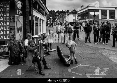 Une jeune famille d'amuseurs publics effectuer dans la high street, Lewes, East Sussex, UK. Banque D'Images