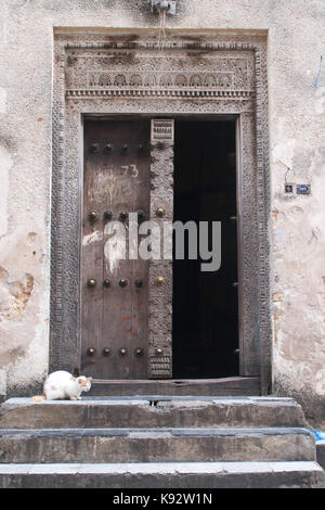 En face de chat porte en bois sculpté orné, Stone Town, Zanzibar, Tanzanie, Afrique de l'Est Banque D'Images