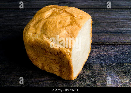 Au four et couper la main miche de pain sur un banc en bois Banque D'Images