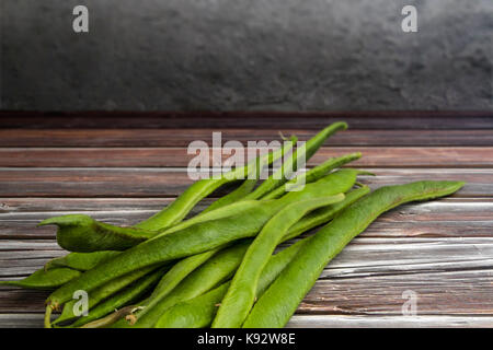 Haricots fraîchement cueillis sur un banc en bois Banque D'Images