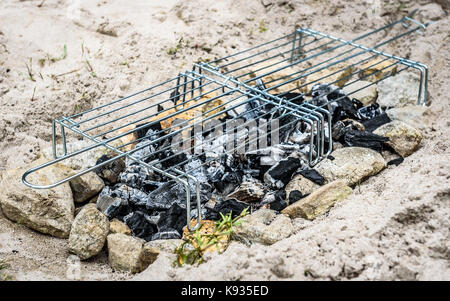 Barbecue Barbecue improvisé fait maison sur plage de sable en vacances. faire un feu, charbon, briquettes barbecue dans le sable avec des roches et des pierres sur le Banque D'Images