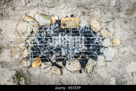 Barbecue Barbecue improvisé fait maison sur plage de sable en vacances. faire un feu, charbon, briquettes barbecue dans le sable avec des roches et des pierres sur le Banque D'Images