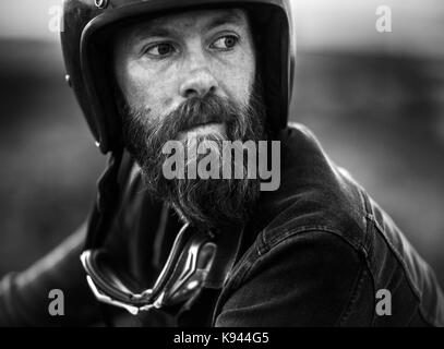 Portrait d'homme barbu portant face ouverte casque, lunettes autour du cou. Banque D'Images