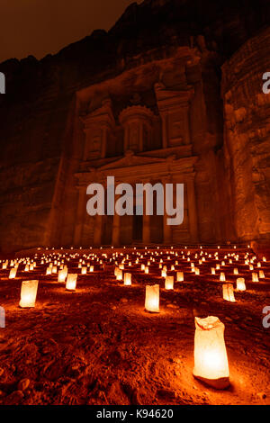Vue extérieure de la roche et de l'architecture des grottes de la façade en grès au al khazneh ou le conseil du trésor à Petra, Jordanie la nuit. une lueur rouge avec s Banque D'Images