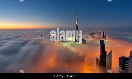 Vue sur le Burj Khalifa et d'autres gratte-ciel au-dessus des nuages à Dubaï, Émirats arabes unis. Banque D'Images