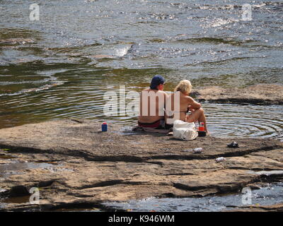 Québec,canada. Couple assis sur des supports dans une rivière peu profonde Banque D'Images