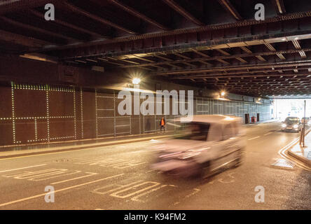 Image floue de la vitesse du trafic qui voyagent dans le cadre de la gare de Leeds, à travers les arches sombres Banque D'Images