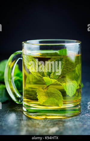 Thé à la menthe délicieux. Les feuilles de menthe et tasse de thé. Banque D'Images