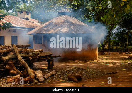 La fumée sortir d'une hutte de cuisine en Ouganda Banque D'Images