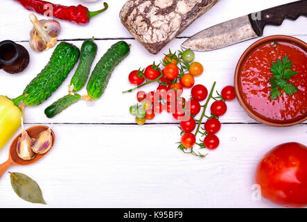 Soupe froide gaspacho espagnol dans une plaque ronde en céramique et des légumes frais ingrédients, vue d'en haut Banque D'Images