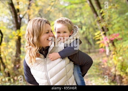 Adorable petit garçon avec sa mère à l'automne park Banque D'Images