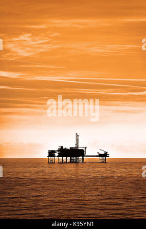 Les plates-formes pétrolières en mer du Nord stations de forage de gaz chaud silhouetted against sky Banque D'Images
