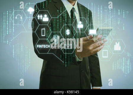 Businessman with fintech icône et internet des objets avec code matrice historique , d'investissement et de la technologie de l'internet financier concept. Banque D'Images