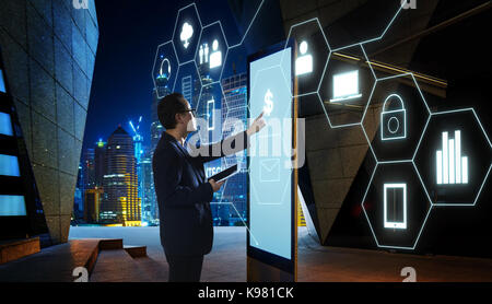 Businessman touching 'money' signe sur l'écran du kiosque numérique avec l'icône fintech infographie . hi-tech concept d'affaires . Banque D'Images