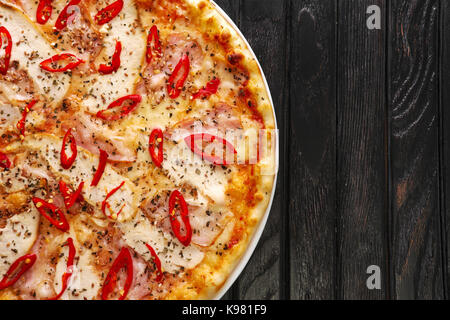 Vue de dessus de savoureux hot chili pizza sur fond de bois foncé Banque D'Images