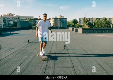 Man riding skateboard sur toit Banque D'Images