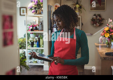 Female florist using digital tablet à son magasin de fleur Banque D'Images