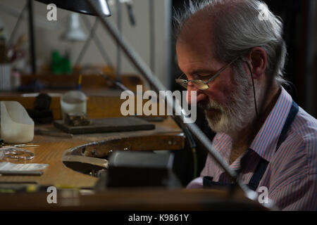 Vue latérale de la goldsmith working at desk in workshop Banque D'Images